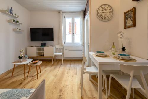 a living room with a table and a clock on the wall at Meraki House in Alghero