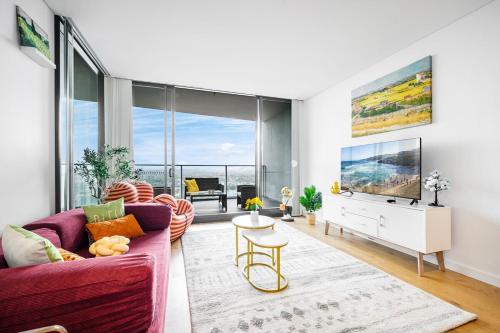 a living room with a purple couch and a tv at Luxury 2Br Apt Near Train Shopping Center in Sydney