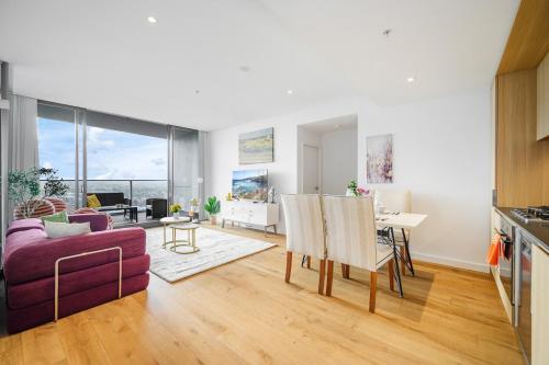 a living room with a purple couch and a table at Luxury 2Br Apt Near Train Shopping Center in Sydney