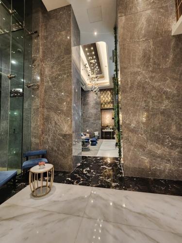 a lobby with a table and chairs in a building at Cozy Studio Apartement South Surabaya in Surabaya