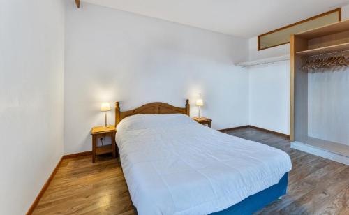 - une chambre avec un lit blanc, 2 tables et une fenêtre dans l'établissement Résidence Les Hauts De Preclaux - Appartement au coeur des Hauts de Préclaux MAE-3471, aux Orres