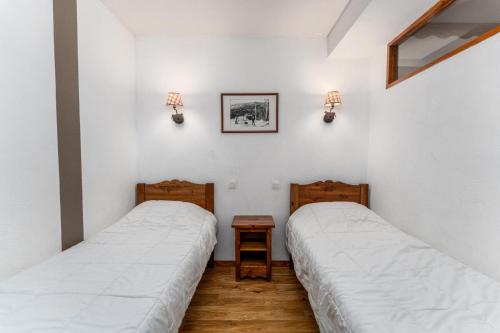 deux lits dans une chambre aux murs blancs dans l'établissement Résidence Les Hauts De Preclaux - Appartement de montagne tout proche des commerces MAE-3481, aux Orres
