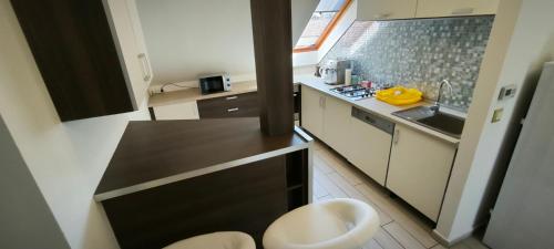 シャールヴァールにあるJoós Family Apartmanの小さなキッチン(黒いカウンター、シンク付)