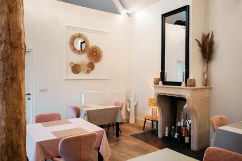 a dining room with a fireplace and a mirror at B&B Anna-Grace in Diksmuide