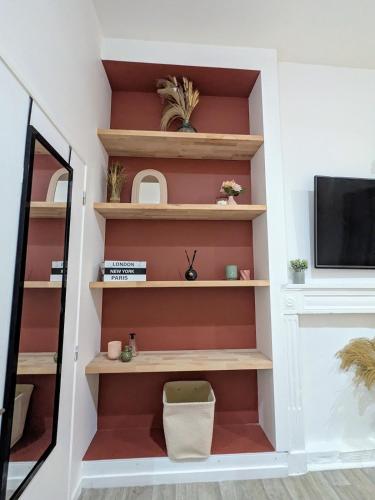 a living room with wooden shelves and a tv at Studio 42 with terrace in Roanne