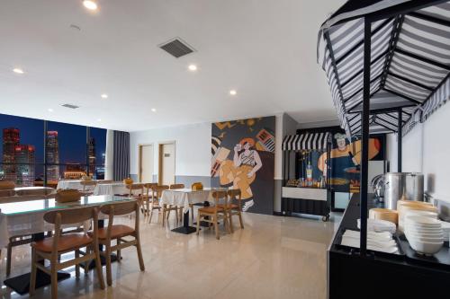 a dining room with tables and chairs and a painting on the wall at Mcsrh Hotel-Chongqing Guanyinqiao in Chongqing