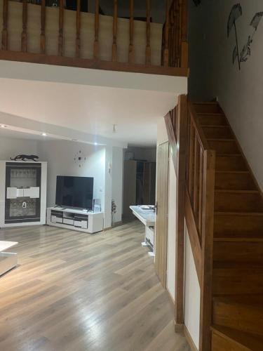 un salon avec un escalier et une télévision dans l'établissement Maison Canet village, à Canet