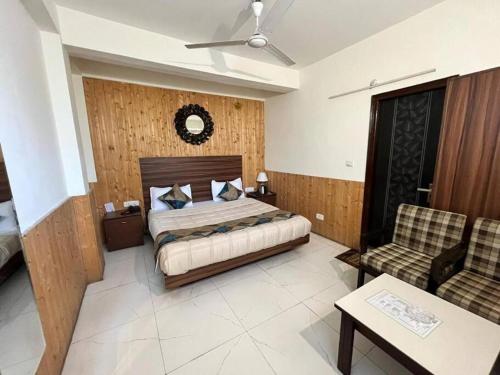 a bedroom with a bed and a couch and a chair at Hotel Hadley in Dharampur