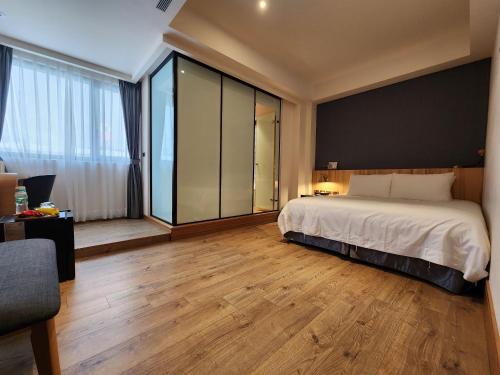 a bedroom with a large bed and a large window at Grange Inn in Taitung City