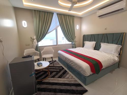 a hotel room with a bed and a window at نستو للشقق الفندقية in Fūwah