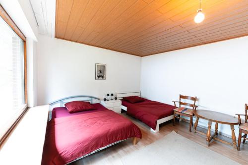 a bedroom with two beds and a table at MonteurGut Apartments Kastanie in Marren