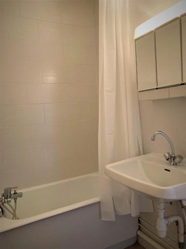 une salle de bain blanche avec un lavabo et une baignoire dans l'établissement Appartement double 19 à Limoges, à Limoges