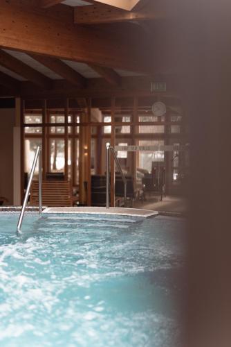 a large swimming pool with blue water in a building at Hotel Die Post in Bad Kleinkirchheim