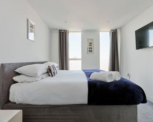 a bedroom with a large bed with white sheets and pillows at Comfortable 3 bedroom apartment in Croydon