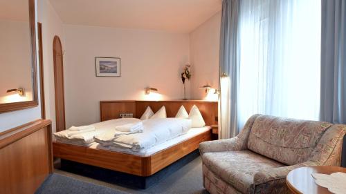 a hotel room with a bed and a couch at Hotel Pflum mit Gästehaus in Nürtingen
