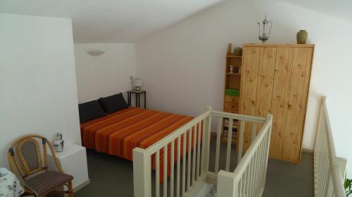 - une petite chambre avec un lit et une armoire en bois dans l'établissement La Vague de Pontaillac 55m2, à Royan