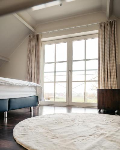 a bedroom with a bed and a large window at B&B Anna-Grace in Diksmuide