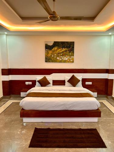 a bedroom with a large bed with a painting on the wall at Hotel Shivalaya by GPH in Haridwār