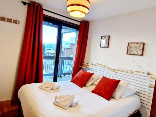une chambre avec un lit avec des rideaux rouges et une fenêtre dans l'établissement Charmant appartement au cœur de Montalbert avec balcon et parking privé, proche des pistes - FR-1-755-33, à Aime La Plagne