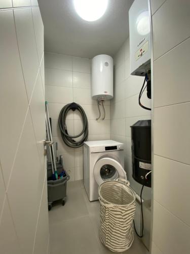 a laundry room with a washing machine and a mirror at Apartment for holidays in Ferizaj