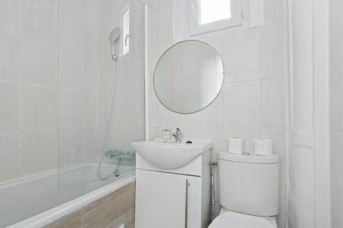 une salle de bain avec toilettes, lavabo et miroir dans l'établissement 533 Suite Longs Pres - Superb Apartment, à Boulogne-Billancourt