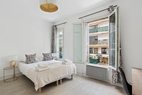 une chambre avec un lit et une grande fenêtre dans l'établissement 533 Suite Longs Pres - Superb Apartment, à Boulogne-Billancourt