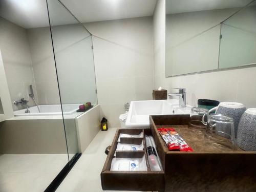 a bathroom with a sink and a bath tub at Ekamai 2 bed room in Khlong Toei