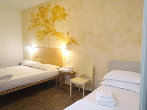 a room with two beds and a table and a chair at OASI DA VINCI in Tignale