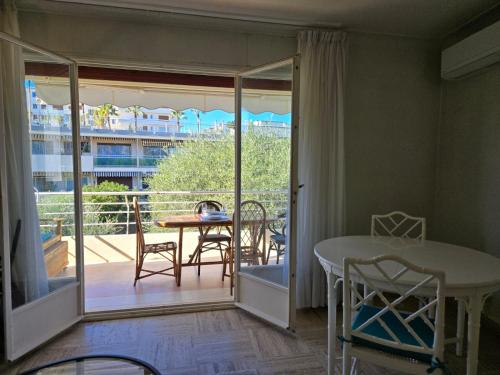 une chambre avec un balcon avec une table et des chaises dans l'établissement LES MOUETTES A, à Cannes