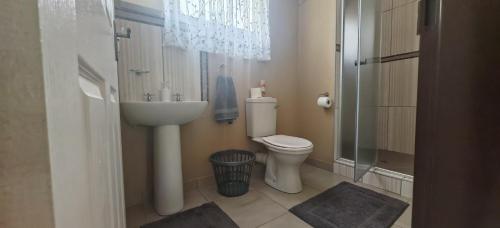 une salle de bains avec toilettes, lavabo et douche dans l'établissement Corea Game Ranch, à Alldays