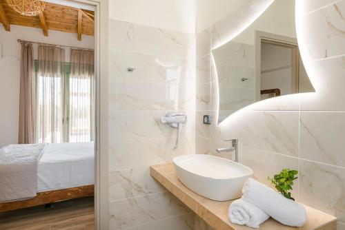 a white bathroom with a sink and a bed at Athina Villa by Vintage Travel in Karavádhos