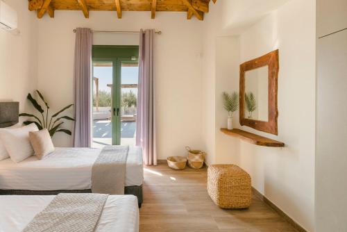 a hotel room with two beds and a balcony at Athina Villa by Vintage Travel in Karavádhos