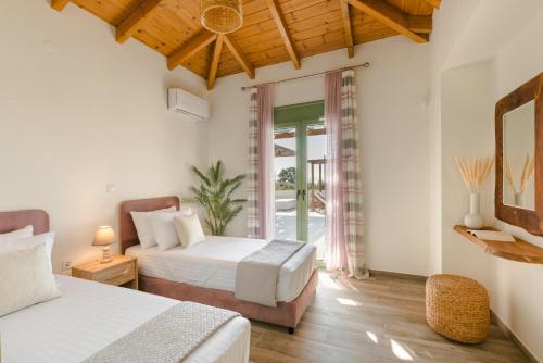 una camera d'albergo con due letti e una finestra di Panagis Villa by Vintage Travel a Karavádhos