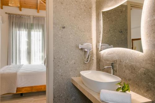 un bagno con un lavandino e un letto di Panagis Villa by Vintage Travel a Karavádhos