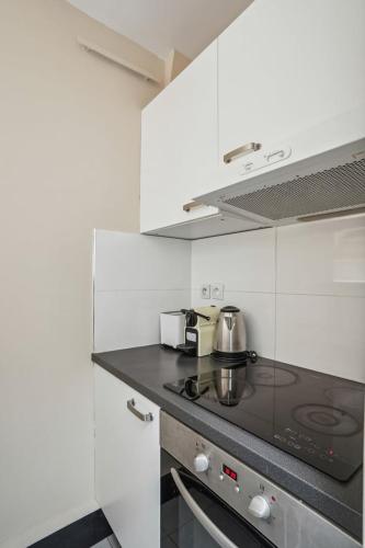 - une cuisine avec une cuisinière dans l'établissement 543 Cardinet Suite - Cozy flat in Grenelle, à Paris