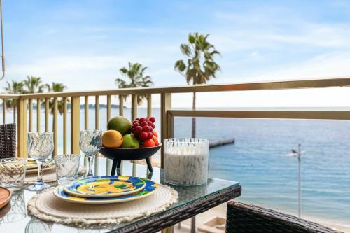 une table avec un bol de fruits sur un balcon dans l'établissement Suite Bleu Vue Mer Confort à Juan-les-Pins, à Antibes