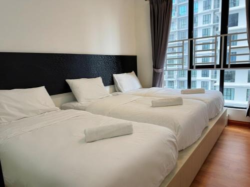 Dos camas una al lado de la otra en un dormitorio. en 1208Paradigm mall Family Cozy up to 11Pax, en Johor Bahru