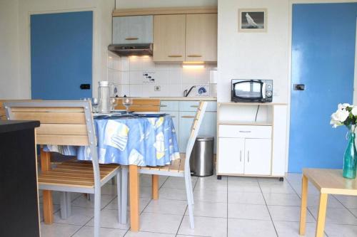 - une cuisine avec une table, une table et des chaises dans l'établissement Appt 2 pièces LA ROCHELLE - LR090-C524, à La Rochelle