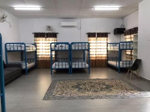 a room with four bunk beds and a rug at As Sufi Villa in Kampung Sungai Air Tawar