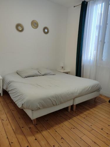 un lit blanc dans une chambre avec une fenêtre dans l'établissement Entire home - Centre Fécamp - 45 Rosa, à Fécamp