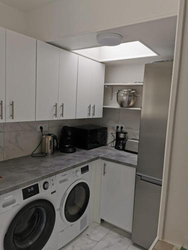 une cuisine blanche avec une machine à laver à l'intérieur dans l'établissement Entire home - Centre Fécamp - 45 Rosa, à Fécamp