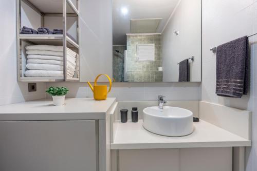 a white bathroom with a sink and a mirror at Maxi Sirius Town 1-Bed Free Pool, Spa, Fast WİFİ Fitness & Beach Access in Aksu