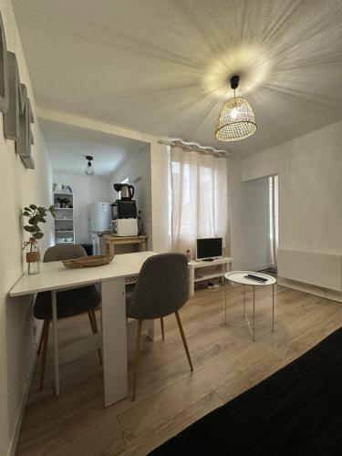 une cuisine et une salle à manger avec une table et des chaises dans l'établissement À deux pas, à Saint-Brieuc