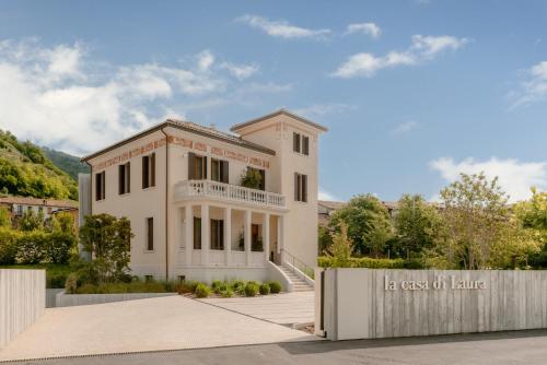 a white house with a sign in front of it at LA CASA DI LAURA in Valdobbiadene