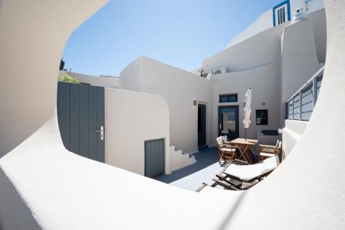 an external view of a house with a table and chairs at Lotza Studios in Oia