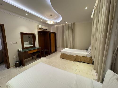 a hotel room with two beds and a mirror at حِمى التحلية للشقق المخدومة in Jeddah