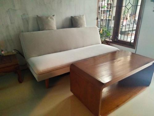 a bed and a wooden table in a room at Homestay Omah in Tabanan