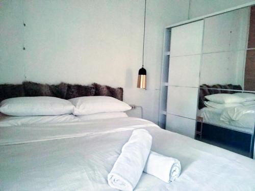 a bedroom with a white bed with towels on it at Homestay Omah in Tabanan