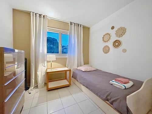 une petite chambre avec un lit et une fenêtre dans l'établissement Lou Paradou Classé 3 etoiles plage à 3mn à pieds parking ByLaConciergerie13, à La Ciotat