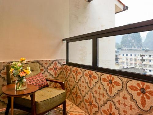 a couch with a vase of flowers on a table at Yangshuo Lisa Boutique Hotel in Yangshuo